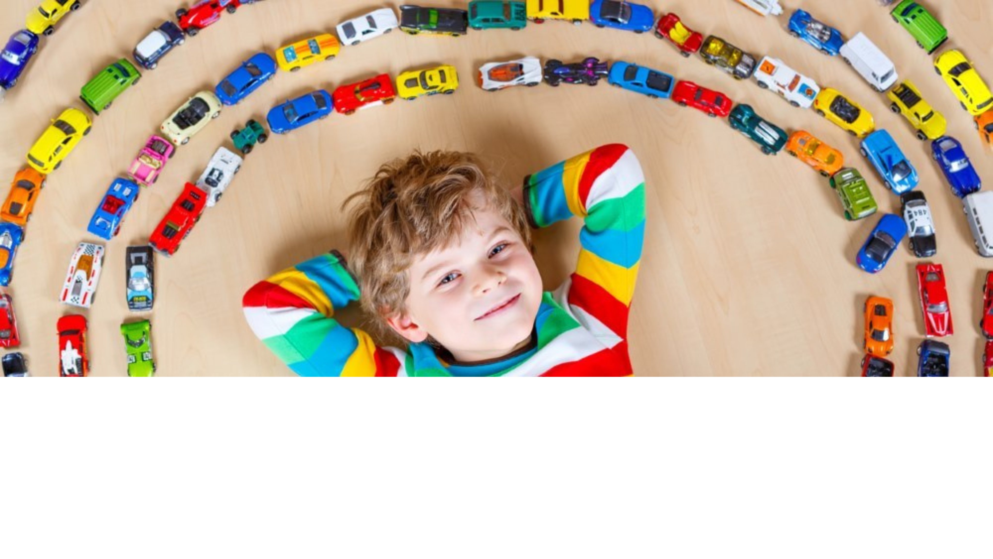 Child laying down with toy cars