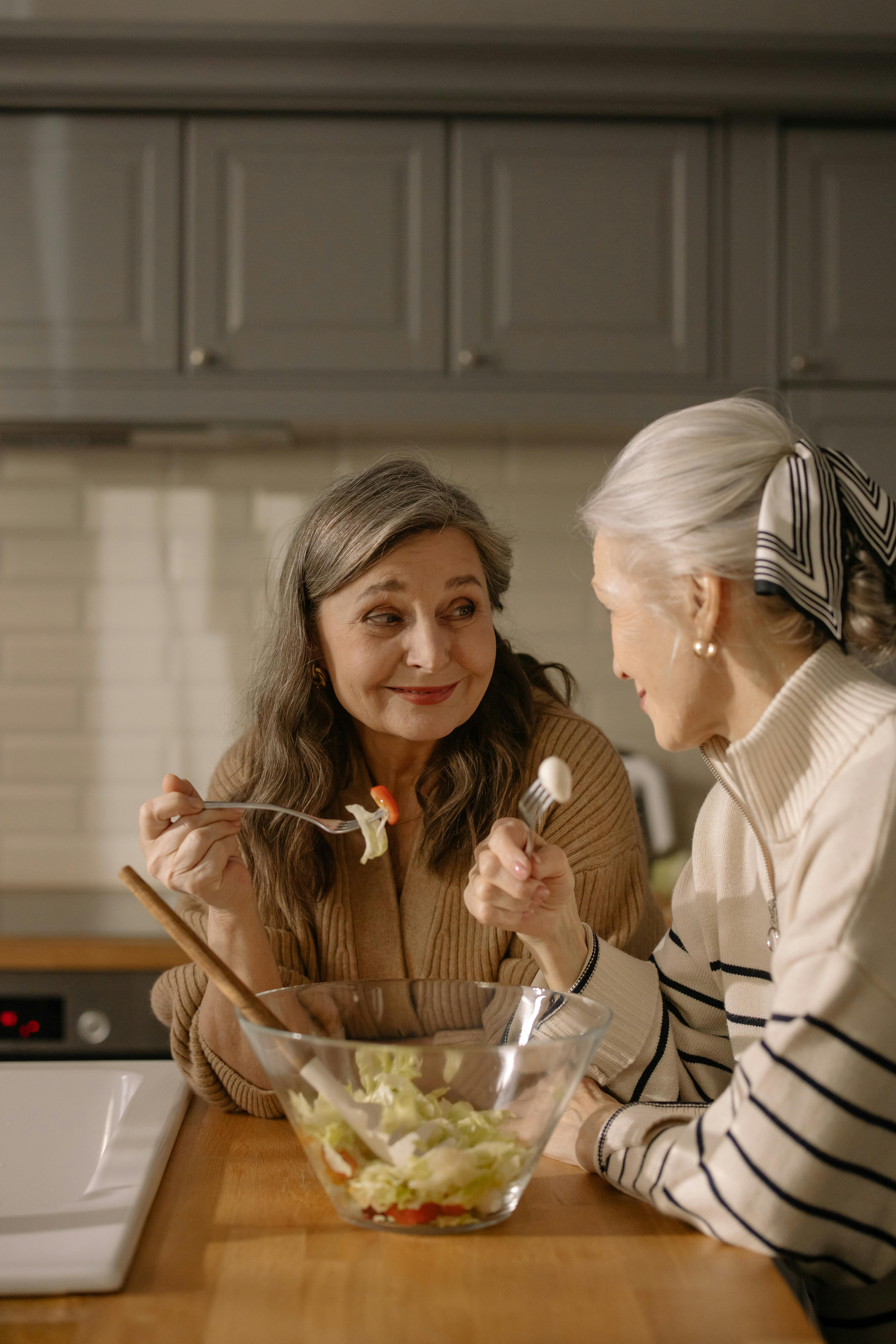 Two 60+ Women Eating Salad