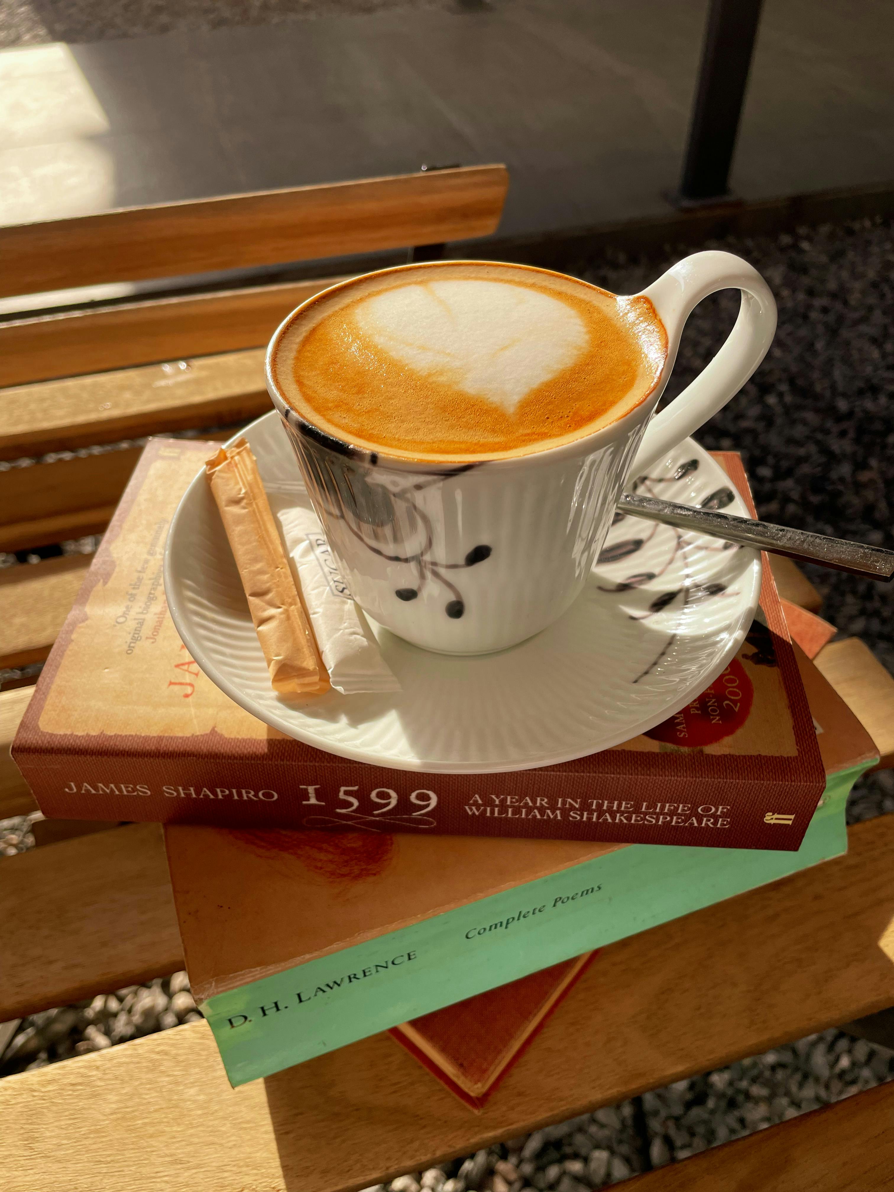 coffee cup on top of book stack