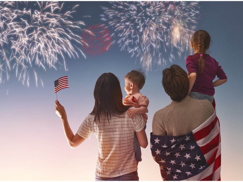 Family of four watching Fireworks with a USA flag in hand