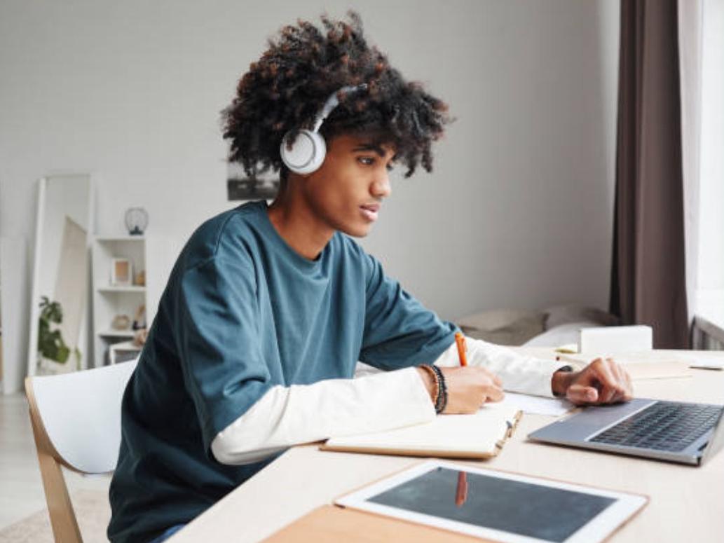 teen doing homeworrk on laptop